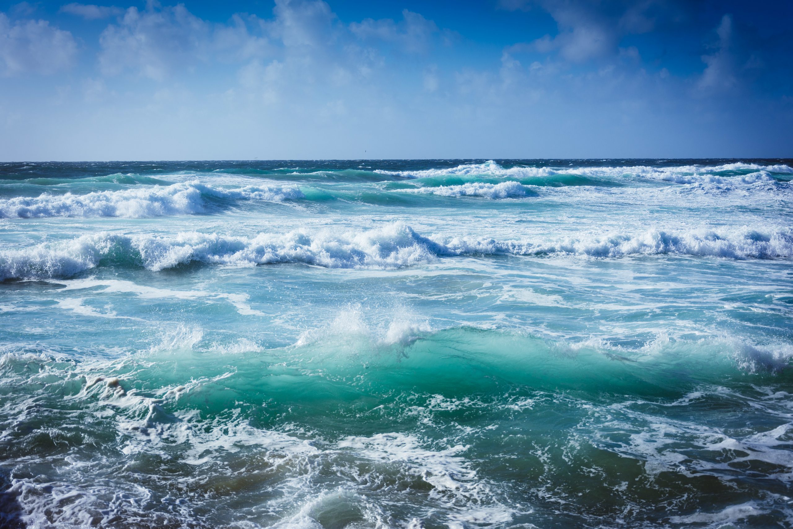 A landscape of a wavy sea under the sunlight and a blue sky - perfect for backgrounds